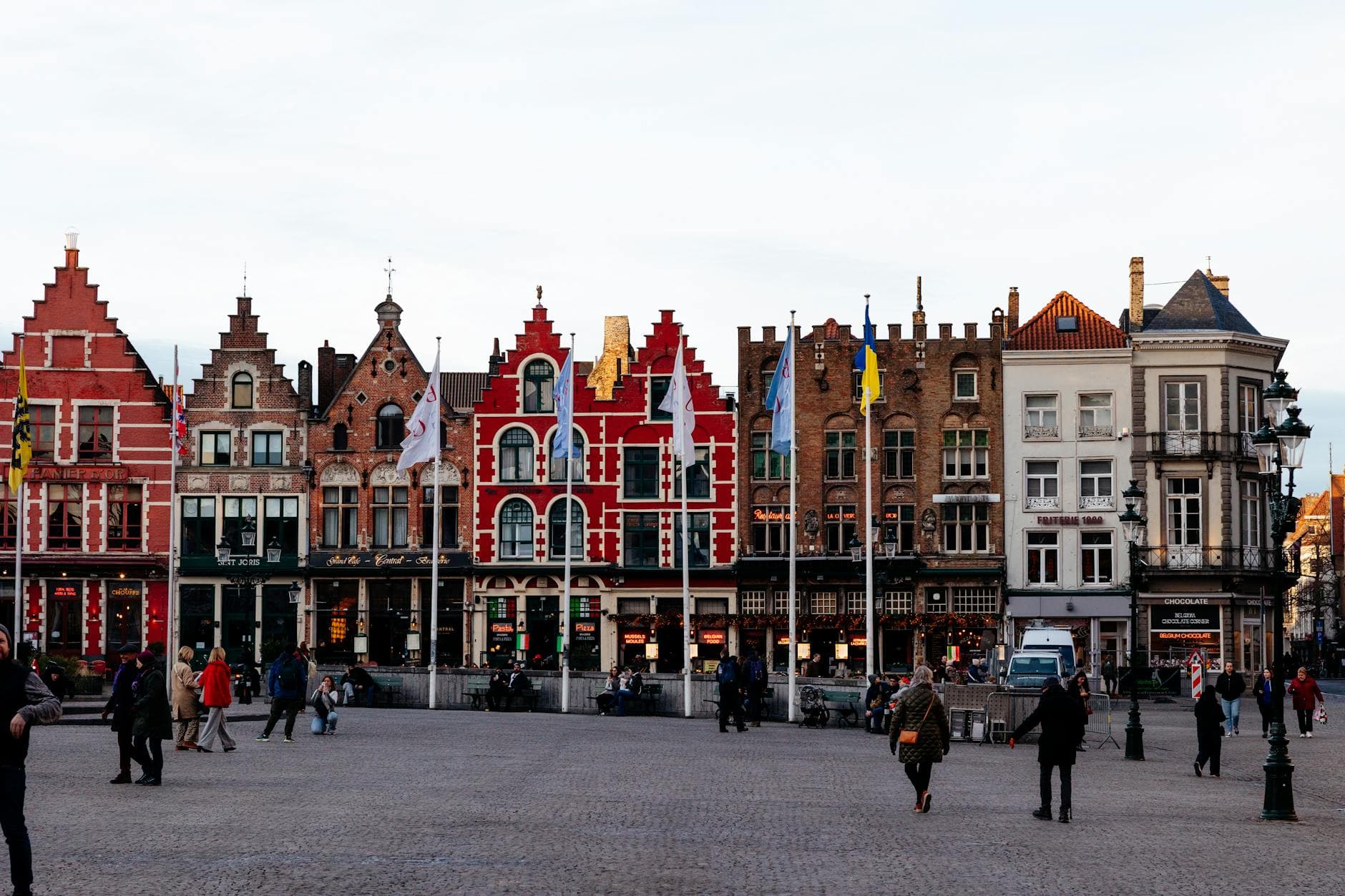 Vibrant medieval buildings lining a square in Bruges, showcasing Flemish architecture.