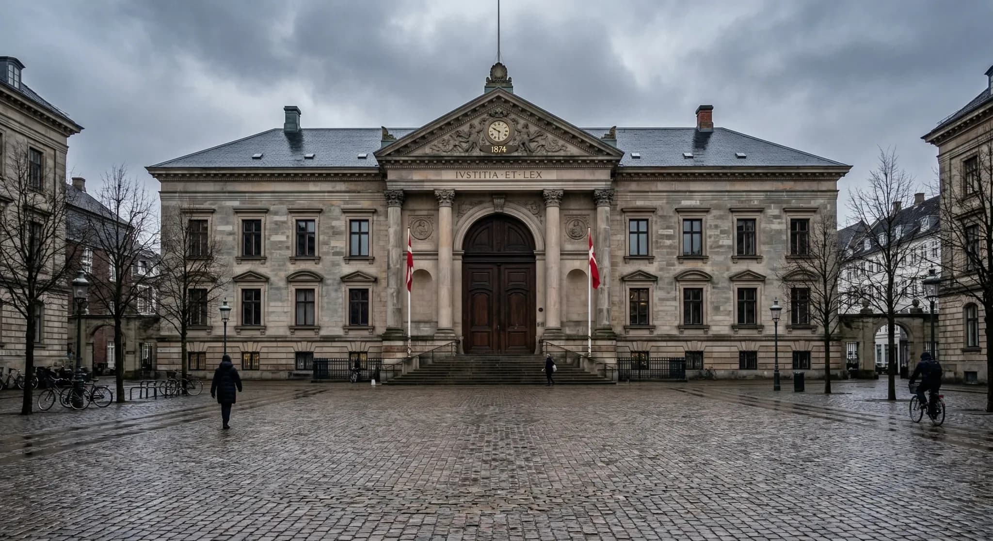 A photorealistic wide-angle shot of a stately European courthouse with a classical facade and large wooden doors, seen from across a quiet cobblestone square. The lighting is cold and natural under a