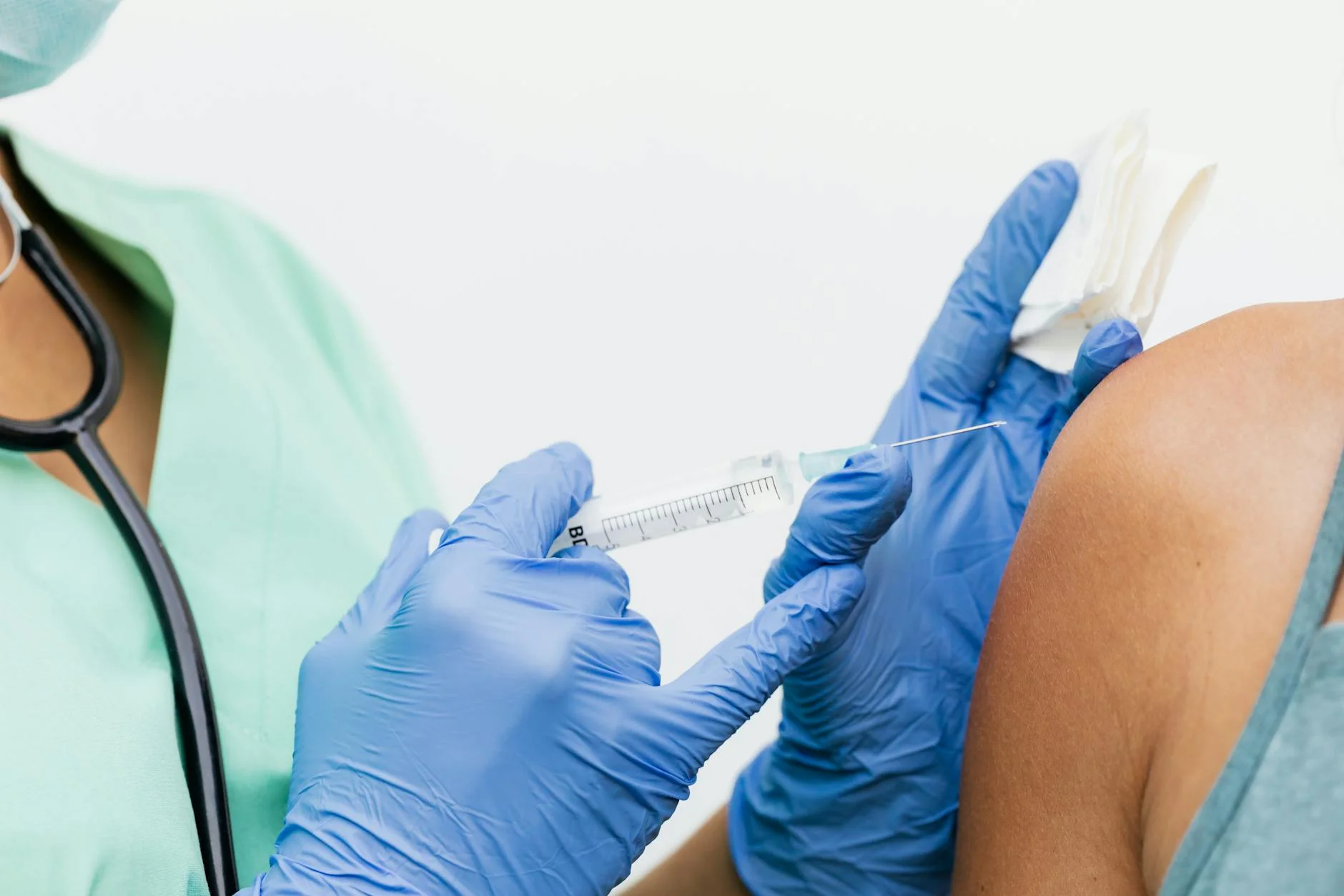 Close-up of a nurse in gloves giving a vaccination to a patient.