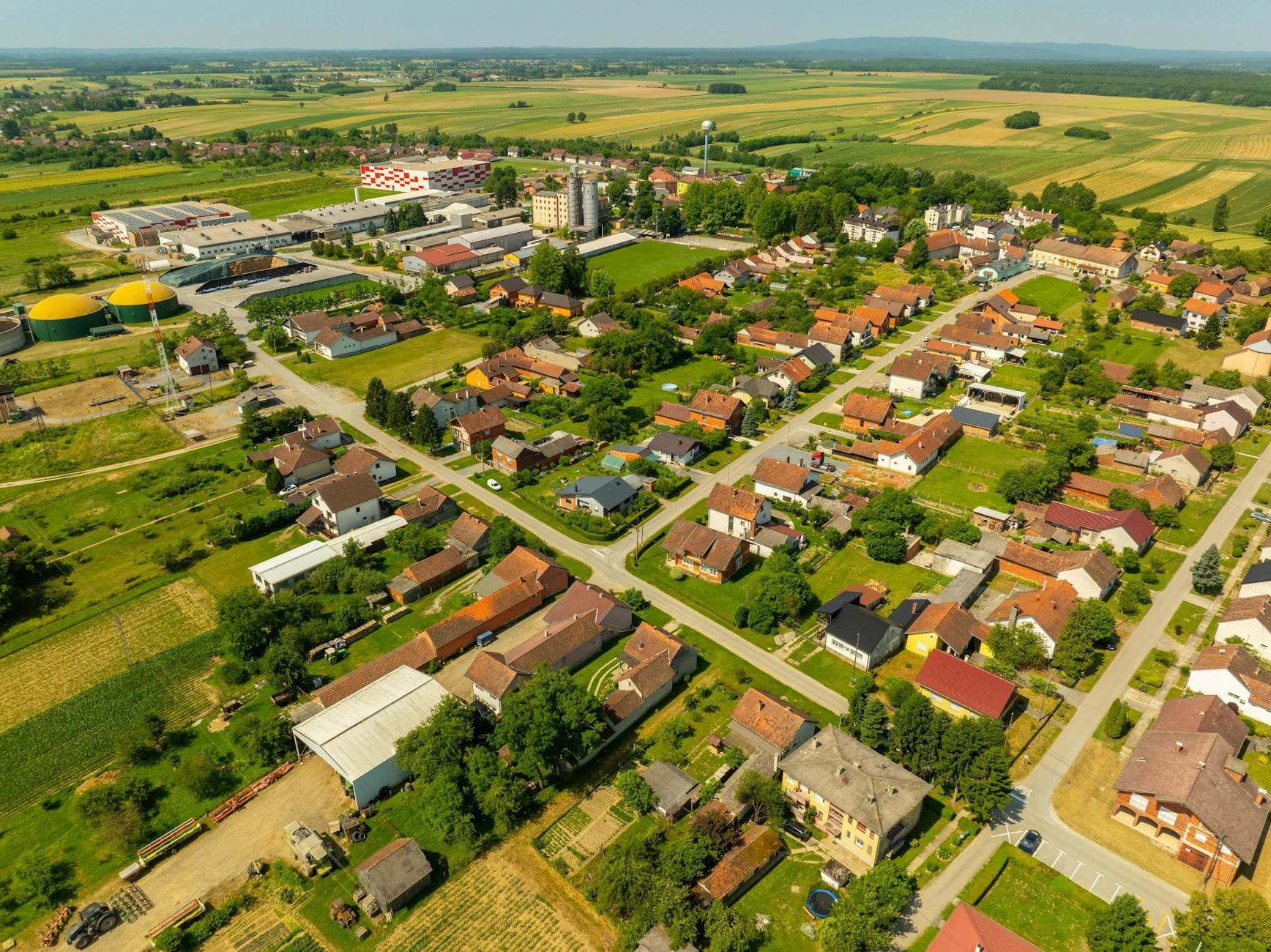 Capture of the sprawling village landscape of Hercegovac, Croatia, showcasing its architecture and fields.