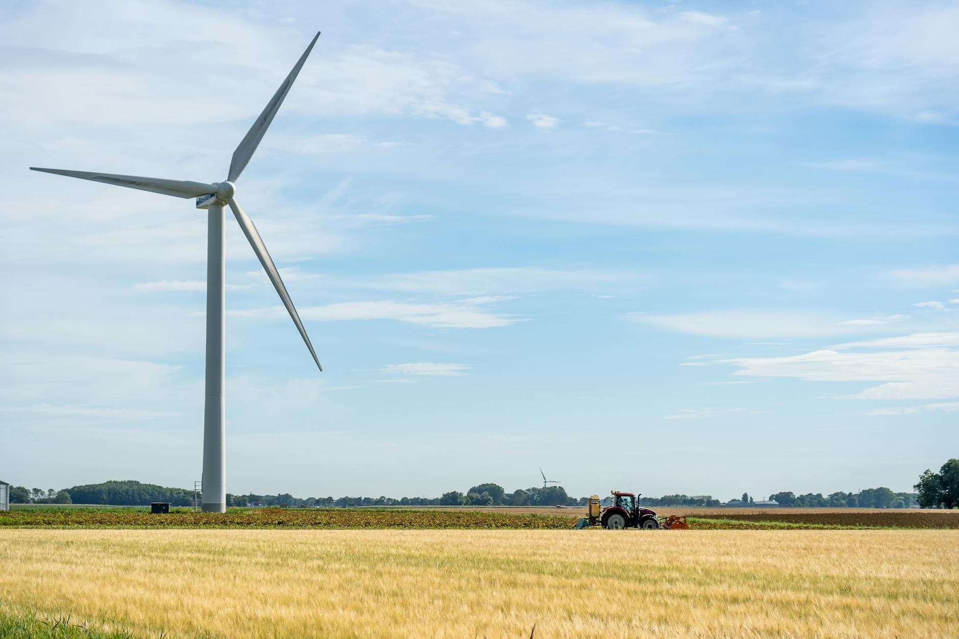 A tranquil view of a wind turbine amid a vast farm landscape in Harlingen, Netherlands.