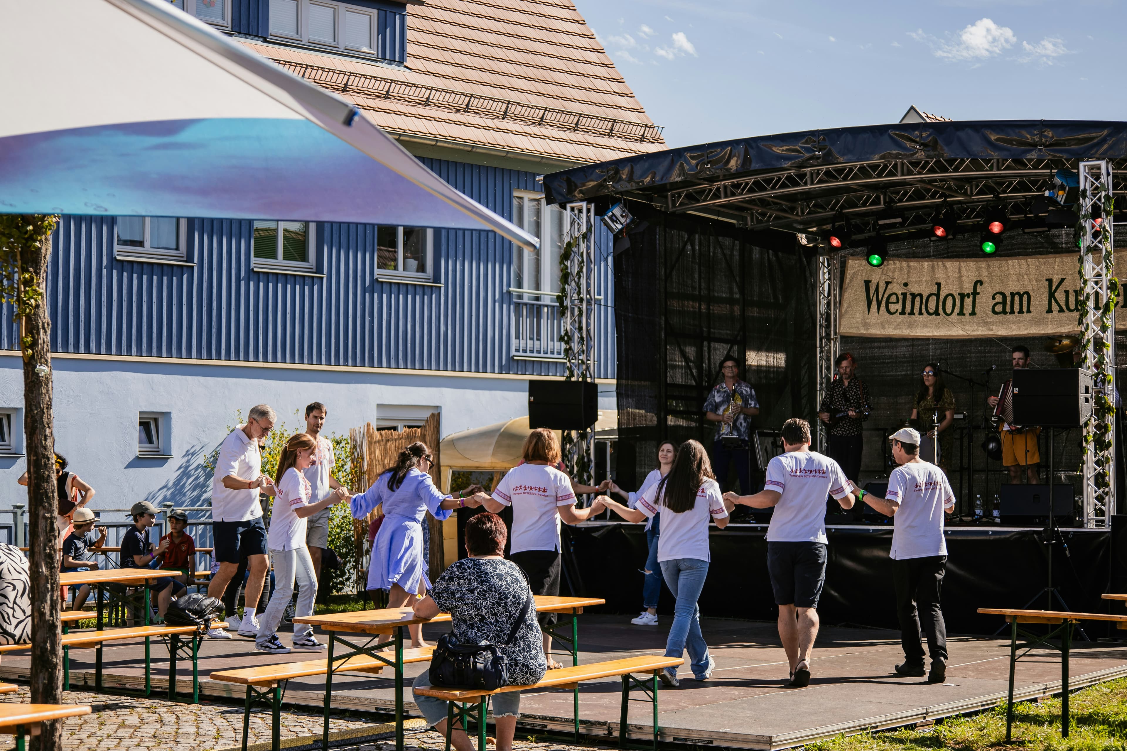 People dancing in a circle at an outdoor festival