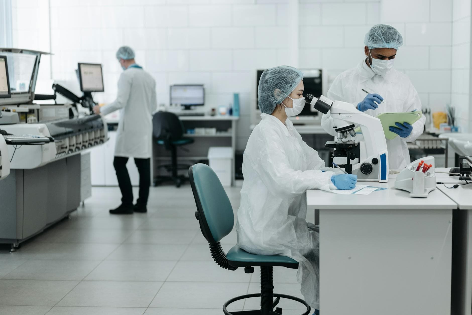 Researchers in protective gear examining samples in a state-of-the-art laboratory setting.